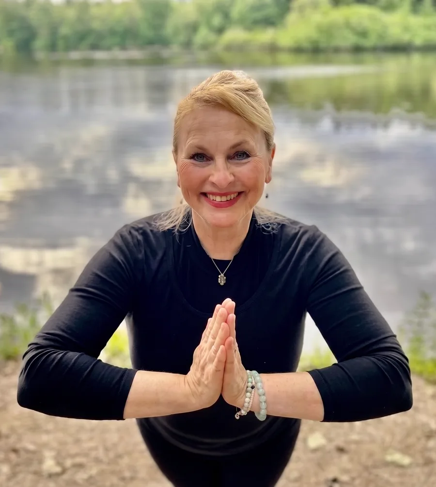 Anna Enko — Yogalehrerin von Atemweite, in Namaste-Haltung am See